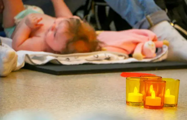 Bebis som får massage med ljuslyktor i förgrunden